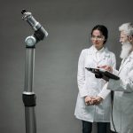 Pesquisadores analisam um sistema robótico em um laboratório de pesquisa médica.