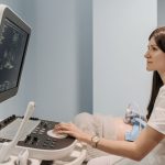 Médica realiza exame de ultrassonografia em uma gestante durante atendimento pré-natal em uma clínica.