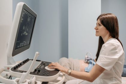Médica realiza exame de ultrassonografia em uma gestante durante atendimento pré-natal em uma clínica.