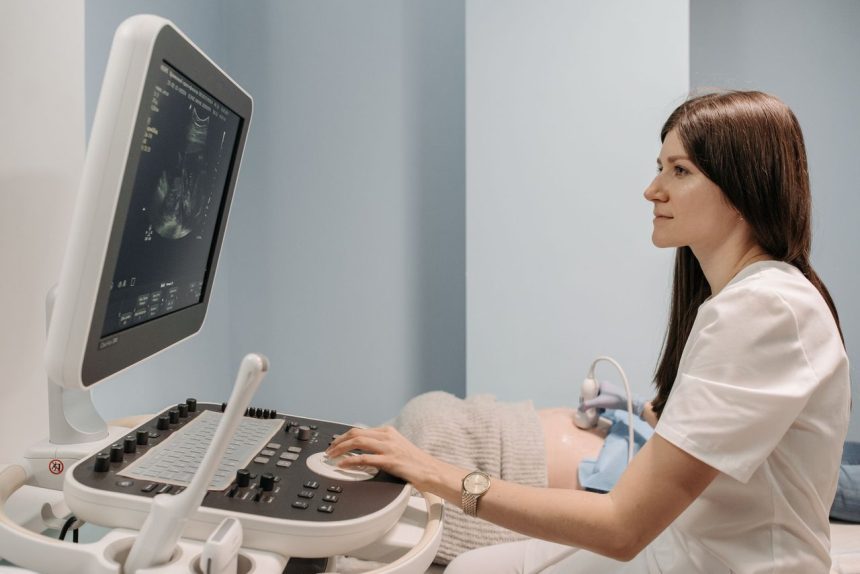 Médica realiza exame de ultrassonografia em uma gestante durante atendimento pré-natal em uma clínica.